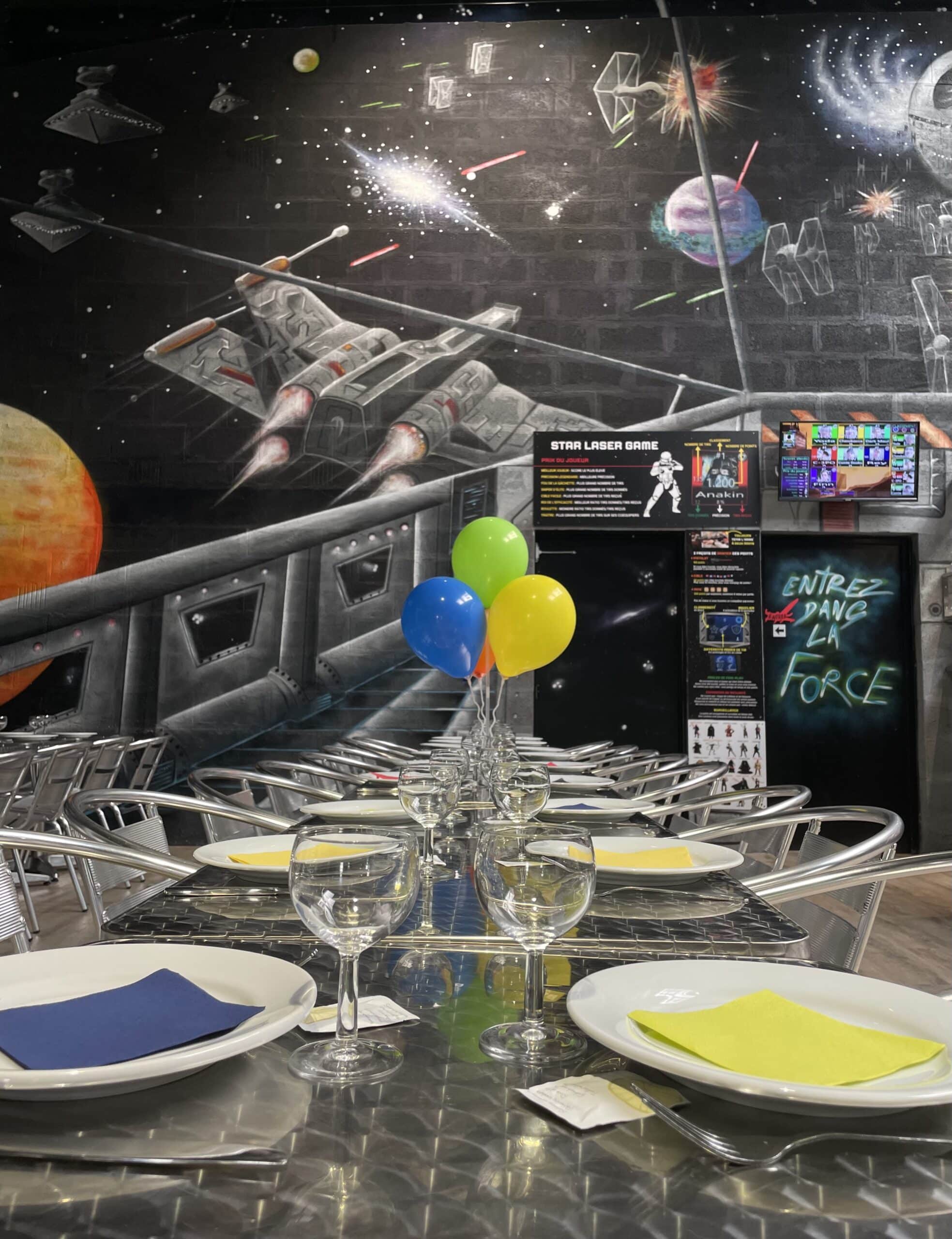 Table de fête Star Laser Game avec ballons et fresque spatiale. Texte : Entrez dans la Force.