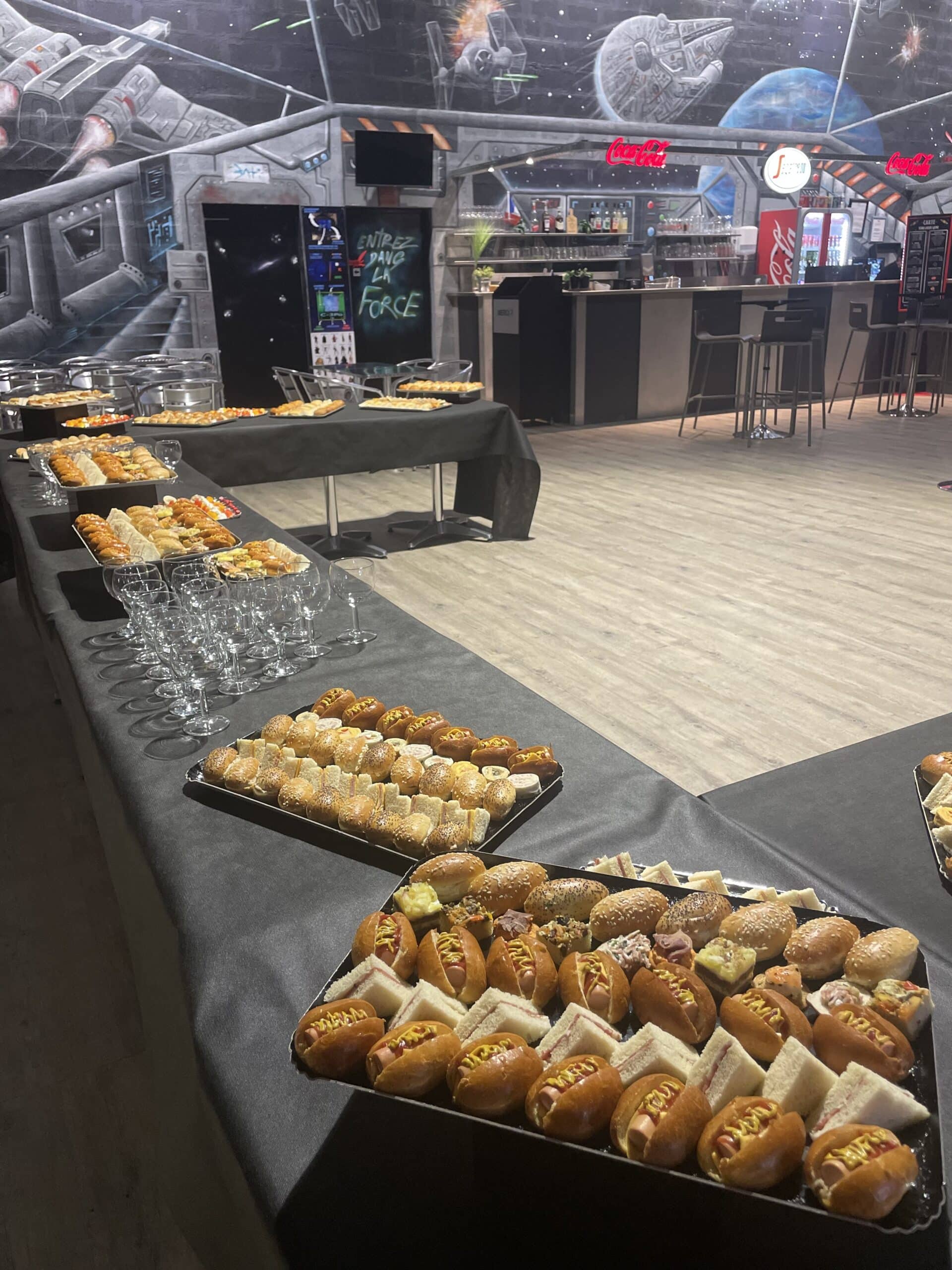 Buffet dînatoire avec mini hot-dogs et sandwichs dans une salle décorée sur le thème Star Wars, Entrez dans la Force.
