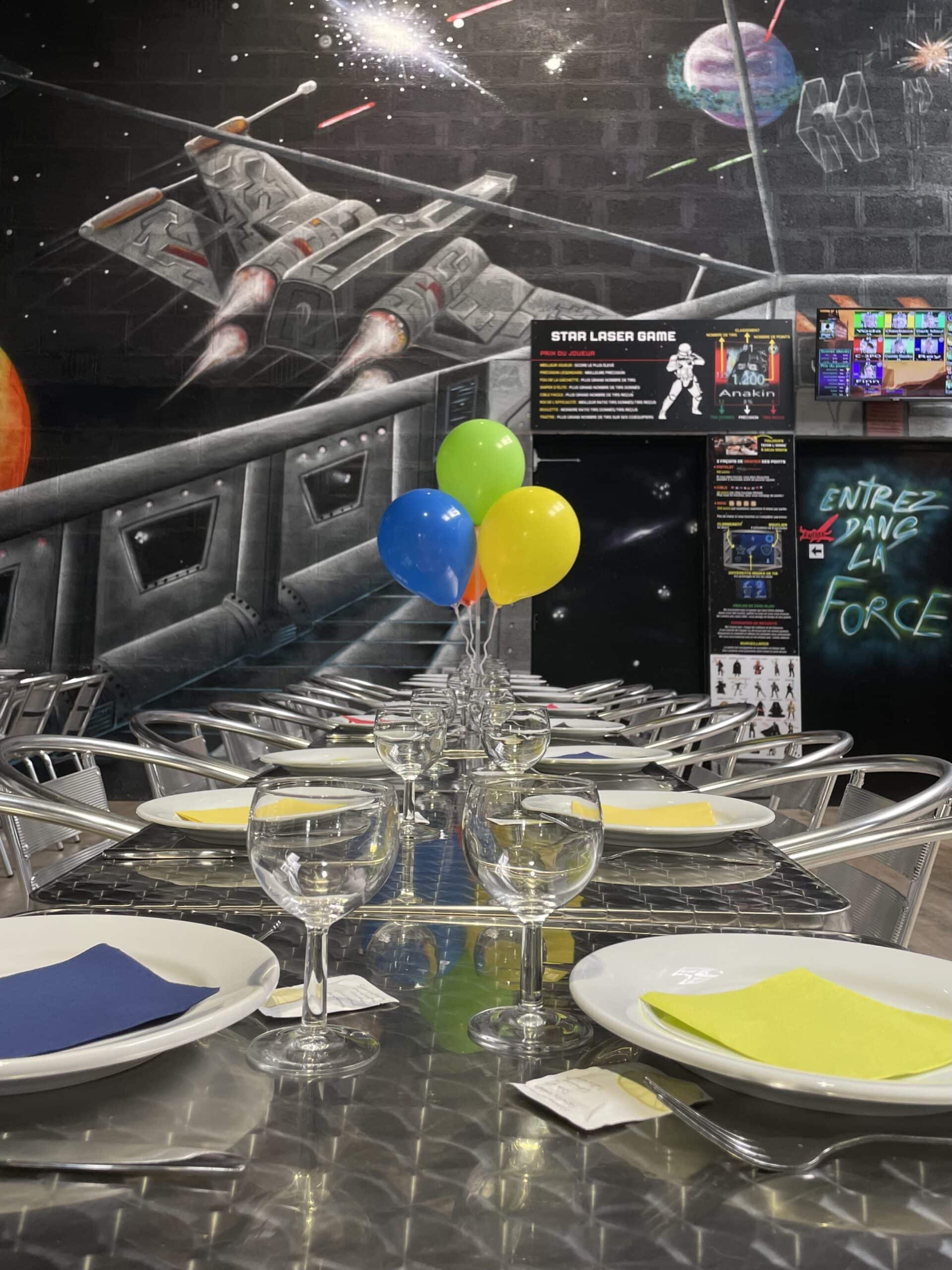 Table de fête décorée au Star Laser Game avec ballons et fresque spatiale "Entrez dans la Force".