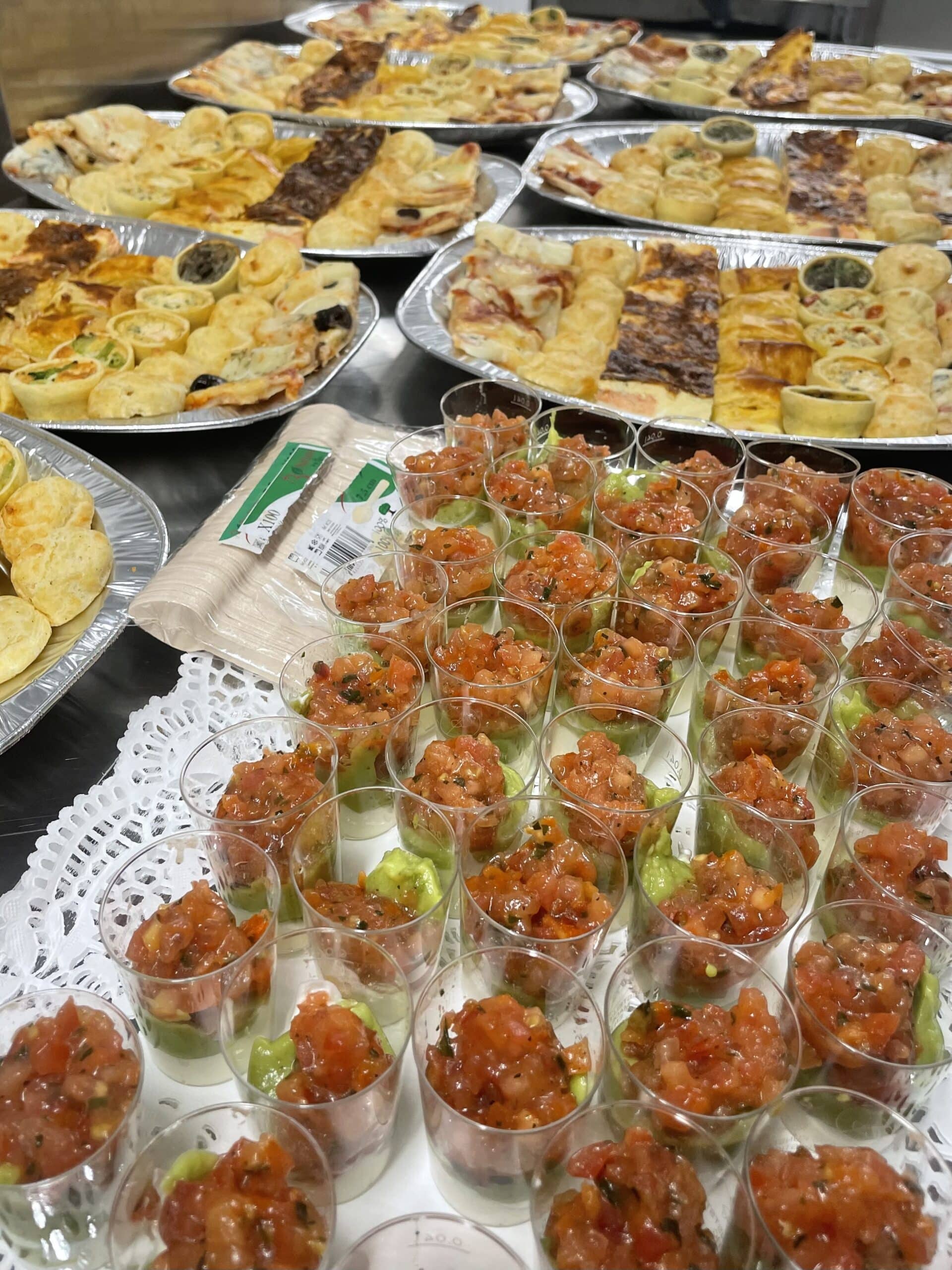 Verrines avocat-tomate et plateaux de mignardises salées, quiches et pizzas pour un service traiteur.