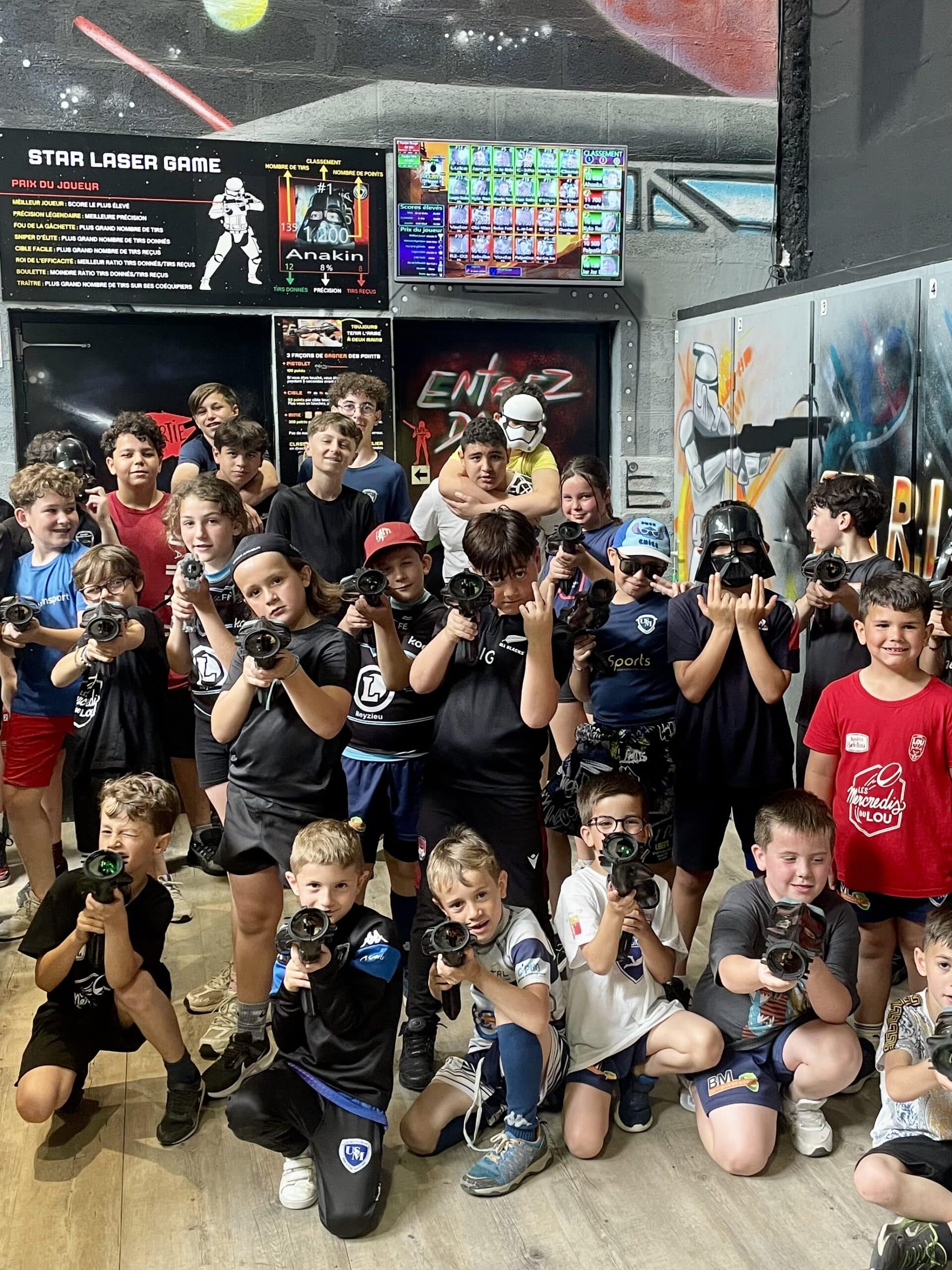 Groupe d'enfants joyeux posant avec des pistolets laser chez Star Laser Game, ambiance Star Wars.