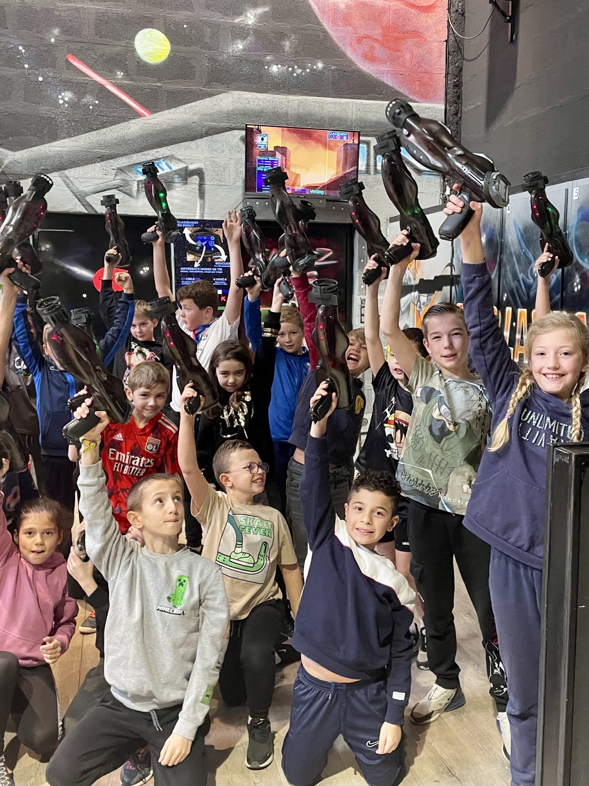 Groupe d'enfants joyeux au laser tag levant leurs pistolets dans un décor spatial avec logo Emirates.